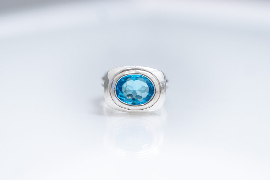 Oval Form sterling silver ring with east-west Swiss blue topaz bezel setting.