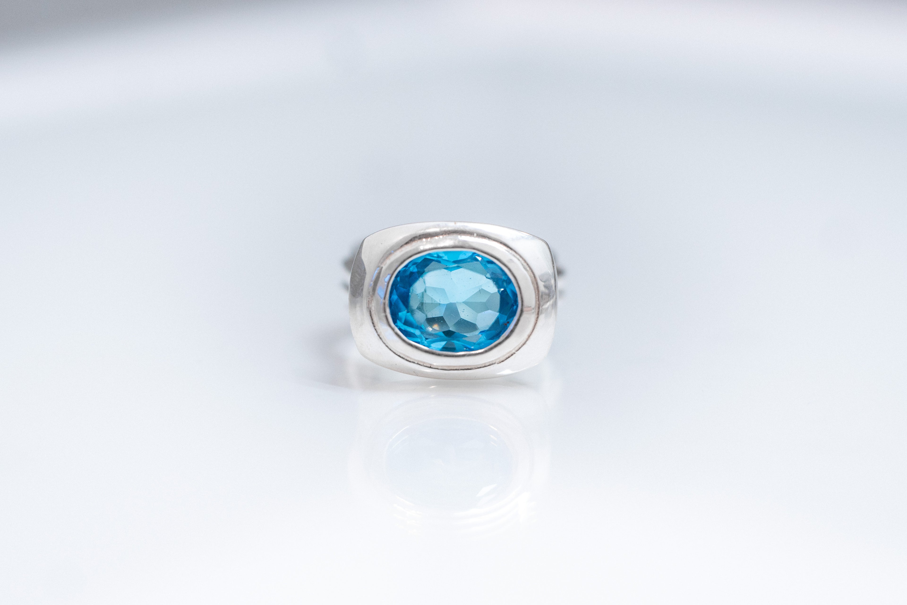 Oval Form sterling silver ring with east-west Swiss blue topaz bezel setting.